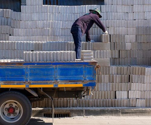 asian-worker-loading-concrete-blocks-into-truck-delivery-customers_43514-912